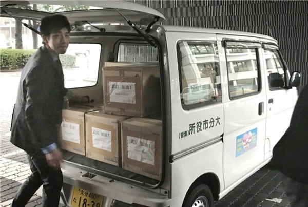 大分市政府工作人员将印有“武汉加油！”的三万只口罩搬上货车。（图片来源：《西日本新闻》网站）
